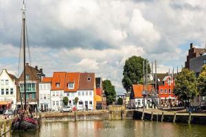 a city with buildings and a river with a boat at Semi-detached house Nordseebrise Niebüll - DNS09100i-L in Niebüll