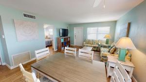 sala de estar con mesa, sillas y sofá en 121 Surf Song Resort, en St Pete Beach