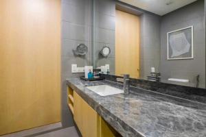 a bathroom with a sink and a large mirror at 188 Suites klcc by Luxe suites in Kuala Lumpur