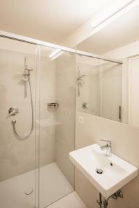 a white bathroom with a shower and a sink at Appartement Steinach in Schenna +4 photos