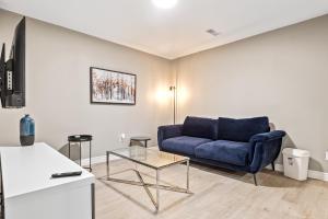 14 minutes from downtown, Luxury home in Nepean في أوتاوا: غرفة معيشة مع أريكة زرقاء وطاولة