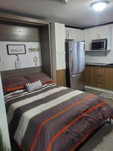 um quarto com uma cama e um frigorífico de aço inoxidável em Motel domaine l'Avantage Inn em Roberval