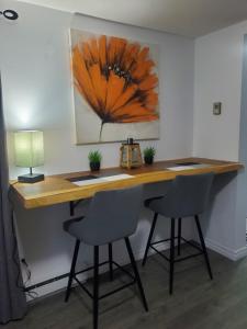 a desk in a room with two chairs and a lamp at Motel domaine l'Avantage Inn in Roberval