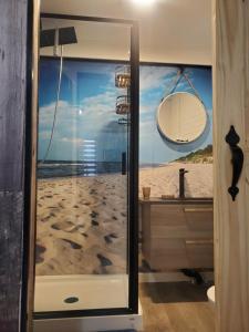 uma casa de banho com chuveiro e vista para a praia em Motel domaine l'Avantage Inn em Roberval
