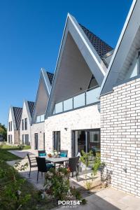 a patio with a table and chairs in front of a house at Ferienwohnung Ostseeinsel Fehmarn in Fehmarn