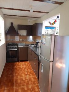 cocina con electrodomésticos de acero inoxidable y suelo de madera en Km0 Hostel en Salento