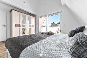 a bedroom with a large bed with a large window at Ferienwohnung Insellodge Fehmarn in Fehmarn
