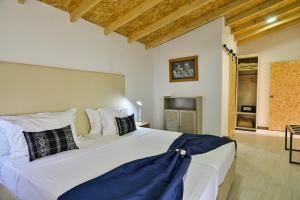 Encosta Azul Guesthouse في Cidade Velha: غرفة نوم بسرير ابيض كبير مع مخدات