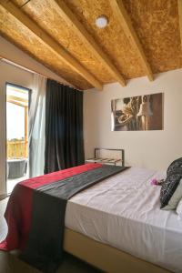 a bedroom with a large bed with a window at Encosta Azul in Cidade Velha