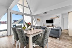 a living room with a table and chairs and a couch at Ferienwohnung Insellodge Fehmarn in Fehmarn