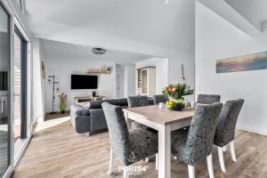 - un salon avec une table, des chaises et un canapé dans l'établissement Ferienwohnung Insellodge Fehmarn, à Fehmarn