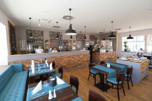 a restaurant with tables and chairs and a bar at Ferienhäuser Baltic Lagoon Haus 14a in Fuhlendorf