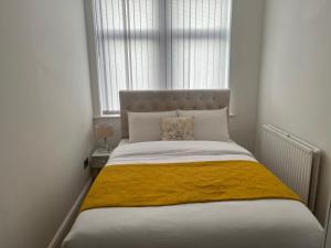 ein Schlafzimmer mit einem Bett mit einer gelben Decke darauf in der Unterkunft Charming 1 bedroom Apartment In The Heart Of Manchester Close to Manchester City Centre And Etihad Stadium in Manchester