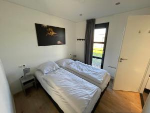 una camera con un letto e una porta con una finestra di Chalet Meeresblick Zweite Reihe Haus Nr 250 a Enkhuizen