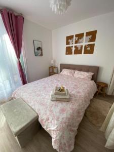 - une chambre avec un lit rose et un plateau dans l'établissement Nouveau F2 au calme proche Paris, à Montigny-lès-Cormeilles