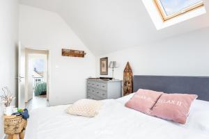 a bedroom with a white bed with pink pillows at Relax in Olpenitz