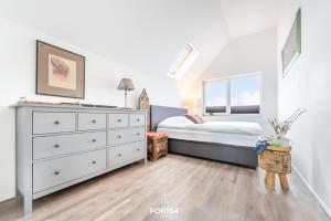 a bedroom with a bed and a dresser at Relax in Olpenitz