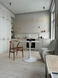 uma cozinha branca com uma mesa e uma cadeira em Uniikki ja tunnelmallinen empireasunto Hämeenlinnan ydinkeskustassa em Hämeenlinna