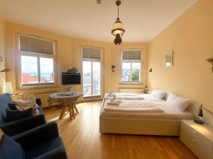 ein Schlafzimmer mit einem Bett und einer Couch und Fenstern in der Unterkunft Alter Reichshof - App 304 in Sassnitz