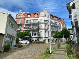 ein großes Gebäude mit einem davor geparkten Auto in der Unterkunft Alter Reichshof - App 304 in Sassnitz