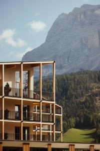 un edificio con una montaña en el fondo en Hotel Lech Da Sompunt, en Badia