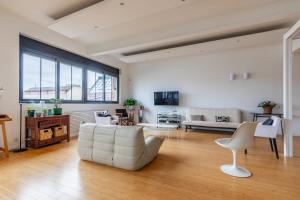 ein Wohnzimmer mit einem weißen Sofa und einem Tisch in der Unterkunft Spacious loft in Pré-Saint-Gervais - Welkeys in Le Pré-Saint-Gervais