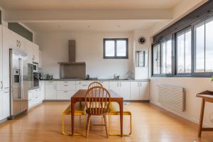 eine Küche mit einem Holztisch und 2 Stühlen in der Unterkunft Spacious loft in Pré-Saint-Gervais - Welkeys in Le Pré-Saint-Gervais