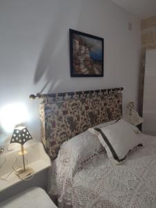 een slaapkamer met een bed en een tafel met een lamp bij Las Palmeras 