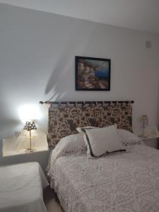 een slaapkamer met een bed en een foto aan de muur bij Las Palmeras 