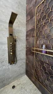 a shower in a bathroom with a black and gold wall at La Caduta Luxury Villa in Livingstone