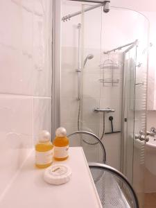 La salle de bains est pourvue d'une douche et de 2 bocaux sur un comptoir. dans l'établissement Winterberg Appartement 21123, à Winterberg