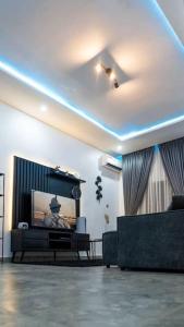 sala de estar con TV y sofá en Alnavi Homes ShortStay Apartment, en Abuja
