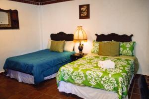 sypialnia z 2 łóżkami i lampką na stole w obiekcie Solache Inn w mieście Zitácuaro