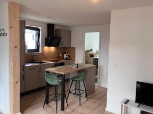 a kitchen with a wooden table and two green chairs at Ferienwohnung Turmblick 