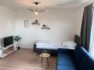 a living room with a blue couch and a tv at Ferienwohnung Turmblick 