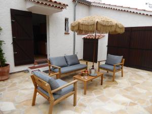 eine Terrasse mit Stühlen, einem Sonnenschirm und einem Tisch in der Unterkunft Villa Berta in Saint-Raphaël