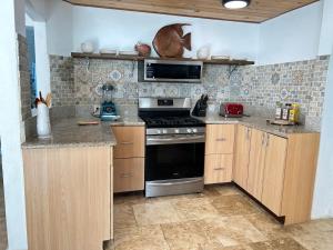 a kitchen with wooden cabinets and a stove top oven at North Star Villa Oceanfront Family-Retreat With Pool in Frederiksted