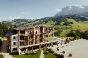 una vista aérea de un edificio con montañas en el fondo en Hotel Lech Da Sompunt, en Badia