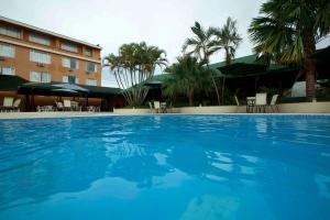 a large blue swimming pool in front of a hotel at Hotel Anaconda in Leticia