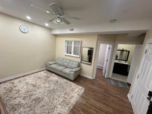 a living room with a couch and a clock on the wall at Queen Bed Apartment with Seamless Living & Kitchen in Newmarket