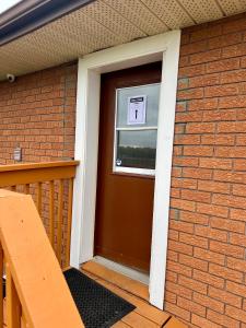 ein Haus mit einer Tür mit einem Schild drauf in der Unterkunft Queen Bed Apartment with Seamless Living & Kitchen in Newmarket