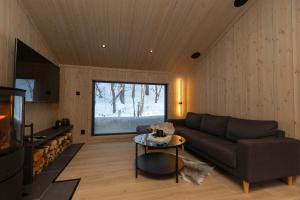 a living room with a couch and a table at High standard cabin in a quiet area in the bossom of nature near Flå in Flå