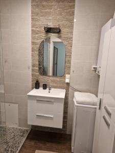 een badkamer met een witte wastafel en een spiegel bij Apartament Komorniki - Osiedla na Skraju Lasu in Komorniki