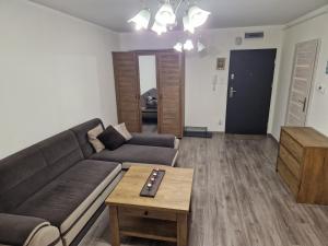 een woonkamer met een bank en een salontafel bij Apartament Komorniki - Osiedla na Skraju Lasu in Komorniki