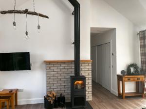 sala de estar con chimenea y fogones en Bayview Byre, en Knock