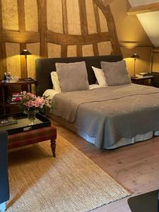 1 dormitorio con cama con almohadas y mesa en Bergerie de la Moutonnière, en Le Pin