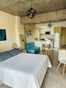ein großes Schlafzimmer mit einem Bett und einer Küche in der Unterkunft Park Garden Tucumán in San Miguel de Tucumán