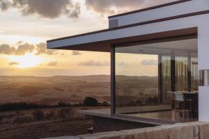 a modern house with a view of the sunset at The Cloud at Sen Vineyard in White Hills