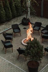 een vuurplaats op een binnenplaats met stoelen en een boom bij Vanaga Ligzda in Baltezers