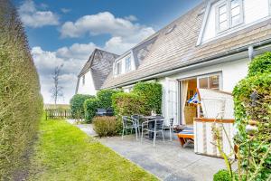 a house with a patio with a table and chairs at Westerhörn 46 15 in Keitum